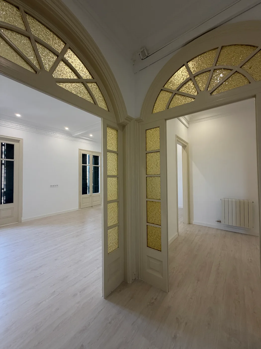Paso entre el salón y el resto del piso, con los arcos de vidrio emplomado conservados