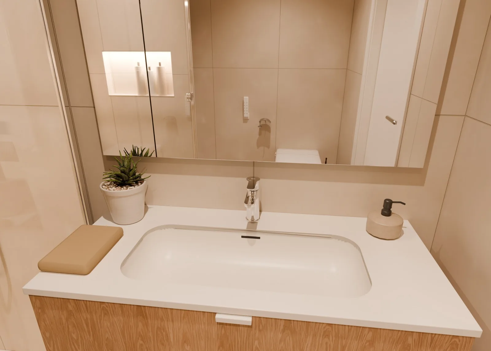 Render 3D del lavabo: encimera blanca sobre mueble de madera y espejo con luz