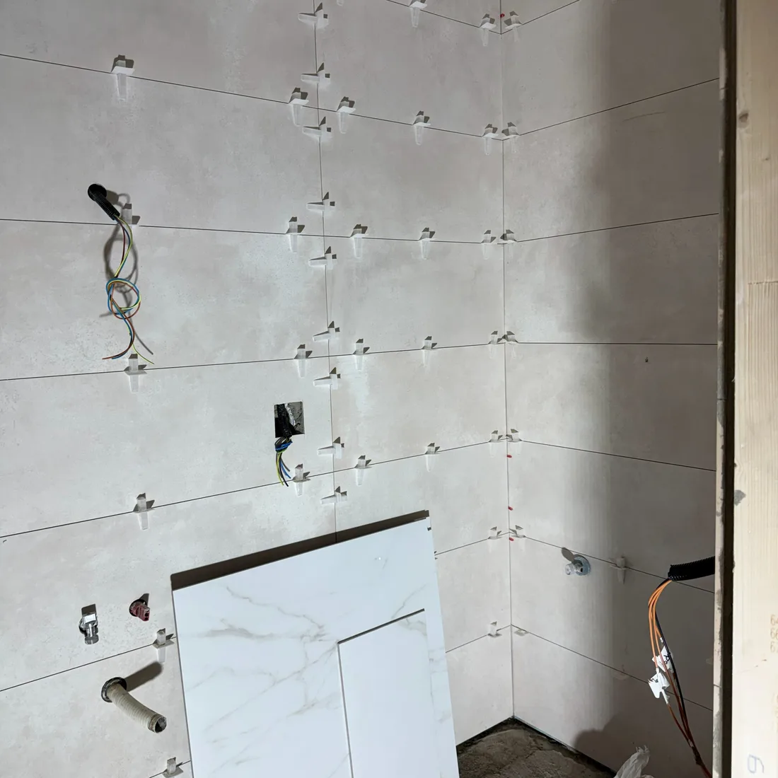 Alicatado de gran formato con crucetas de nivelación durante una reforma de baño en Barcelona
