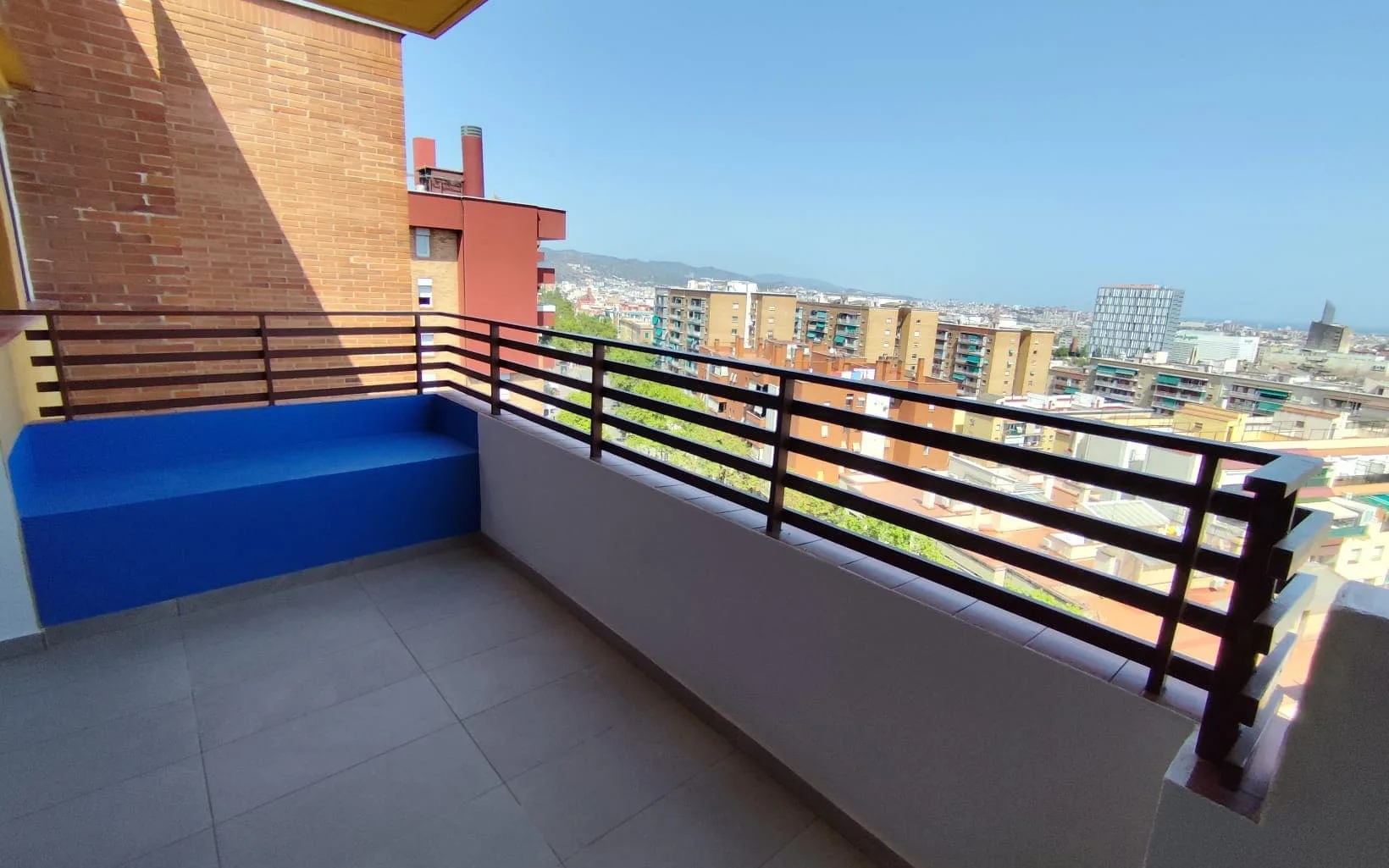 Balcó reformat amb paviment nou i banc d’obra en un habitatge de Barcelona