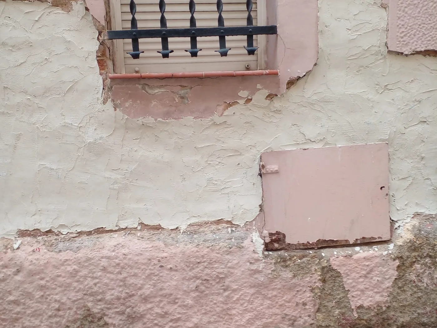 Render repair to a façade around a barred window, an Obrescat project in Barcelona