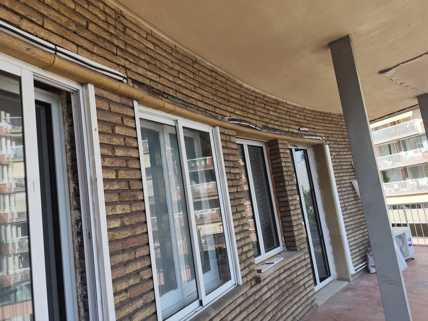 Galería curva con ventanas nuevas montadas en una reforma de vivienda en Barcelona