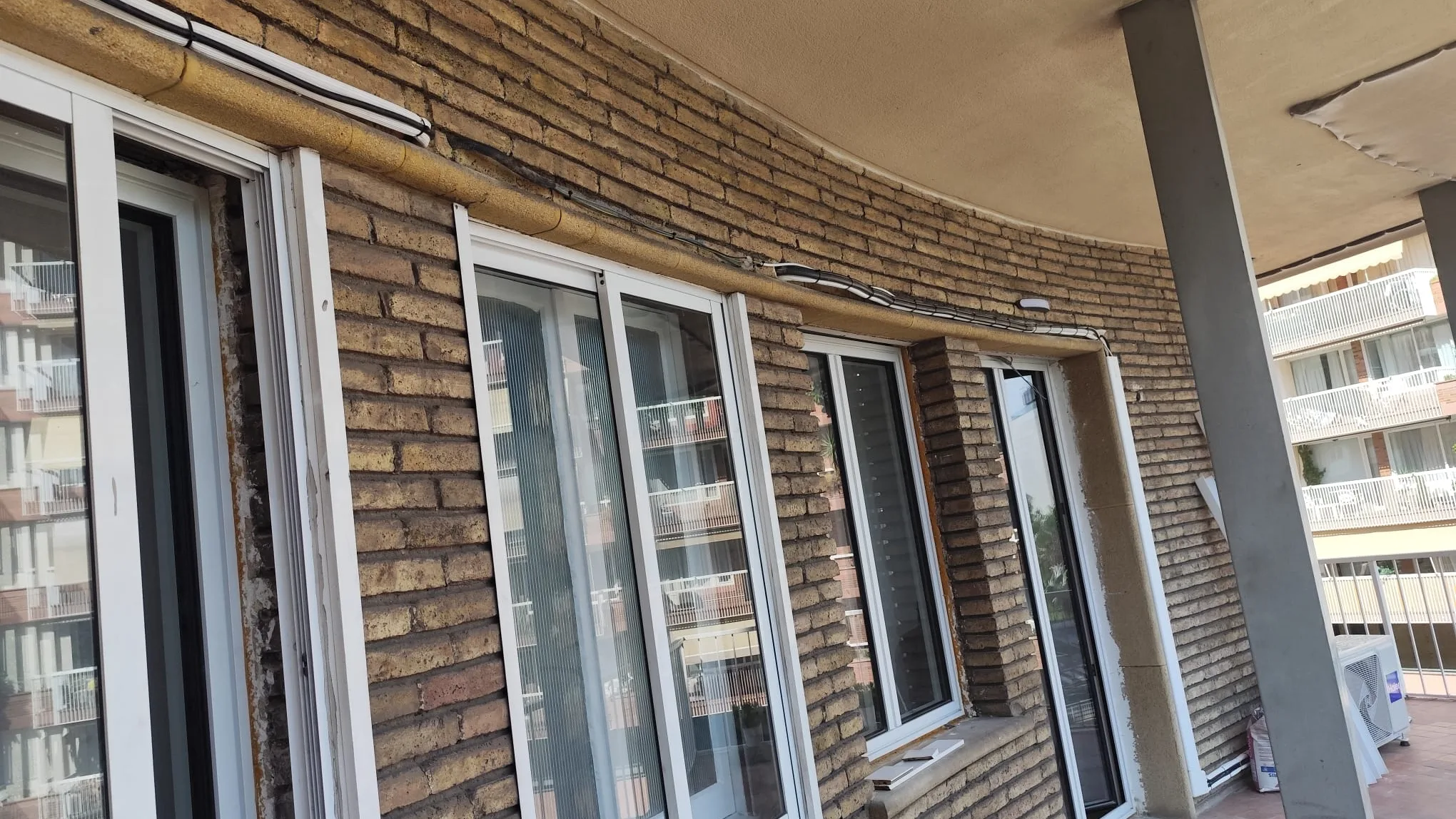 Galeria corba amb finestres noves muntades en una reforma d’habitatge a Barcelona