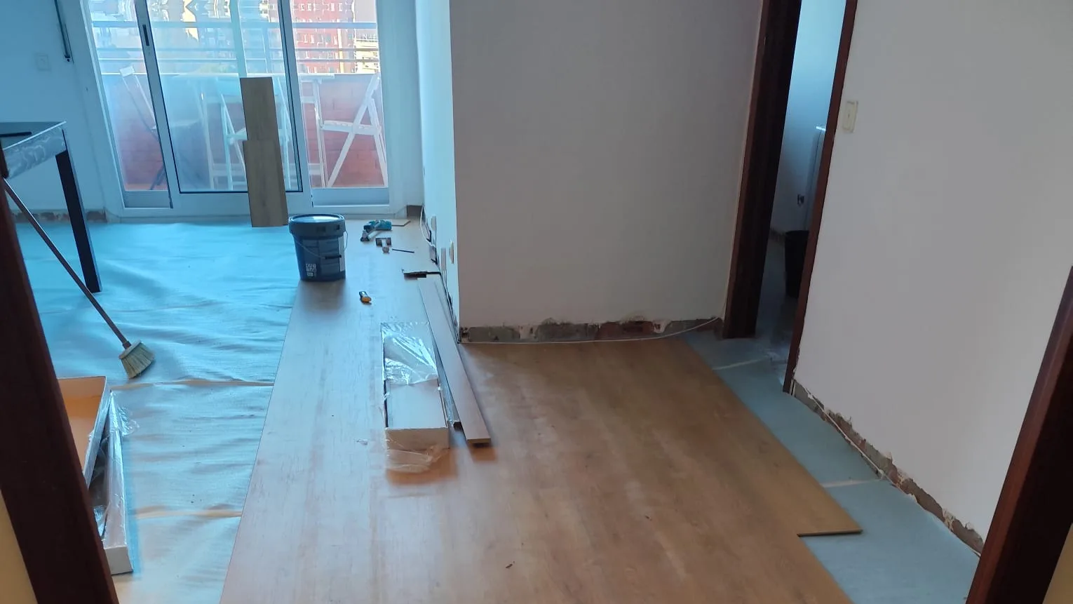 Col·locació del terra laminat sobre la làmina aïllant en un habitatge reformat per Obrescat a Barcelona
