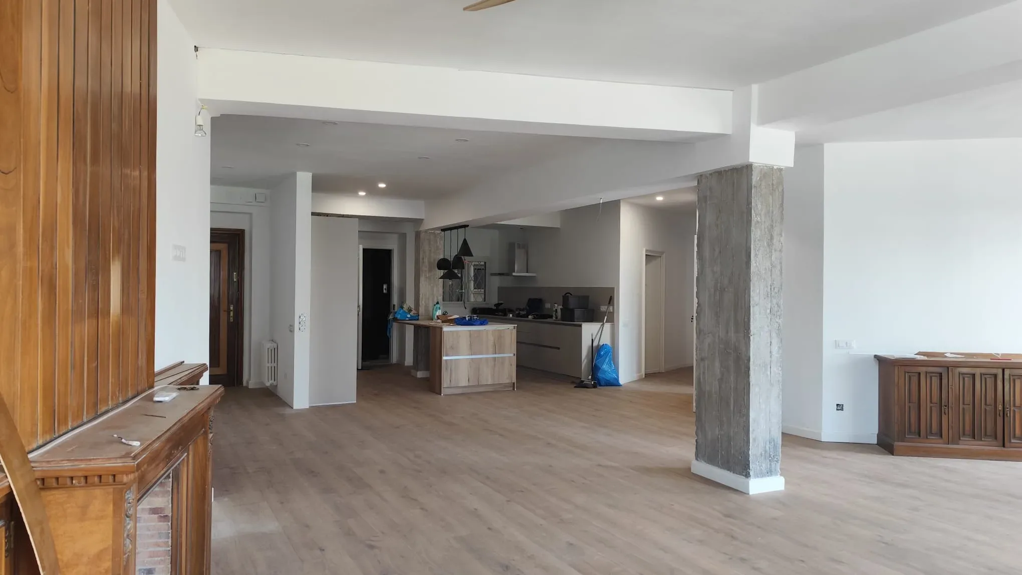 Saló diàfan amb pilars vistos i terra laminat després d’una reforma integral a Barcelona