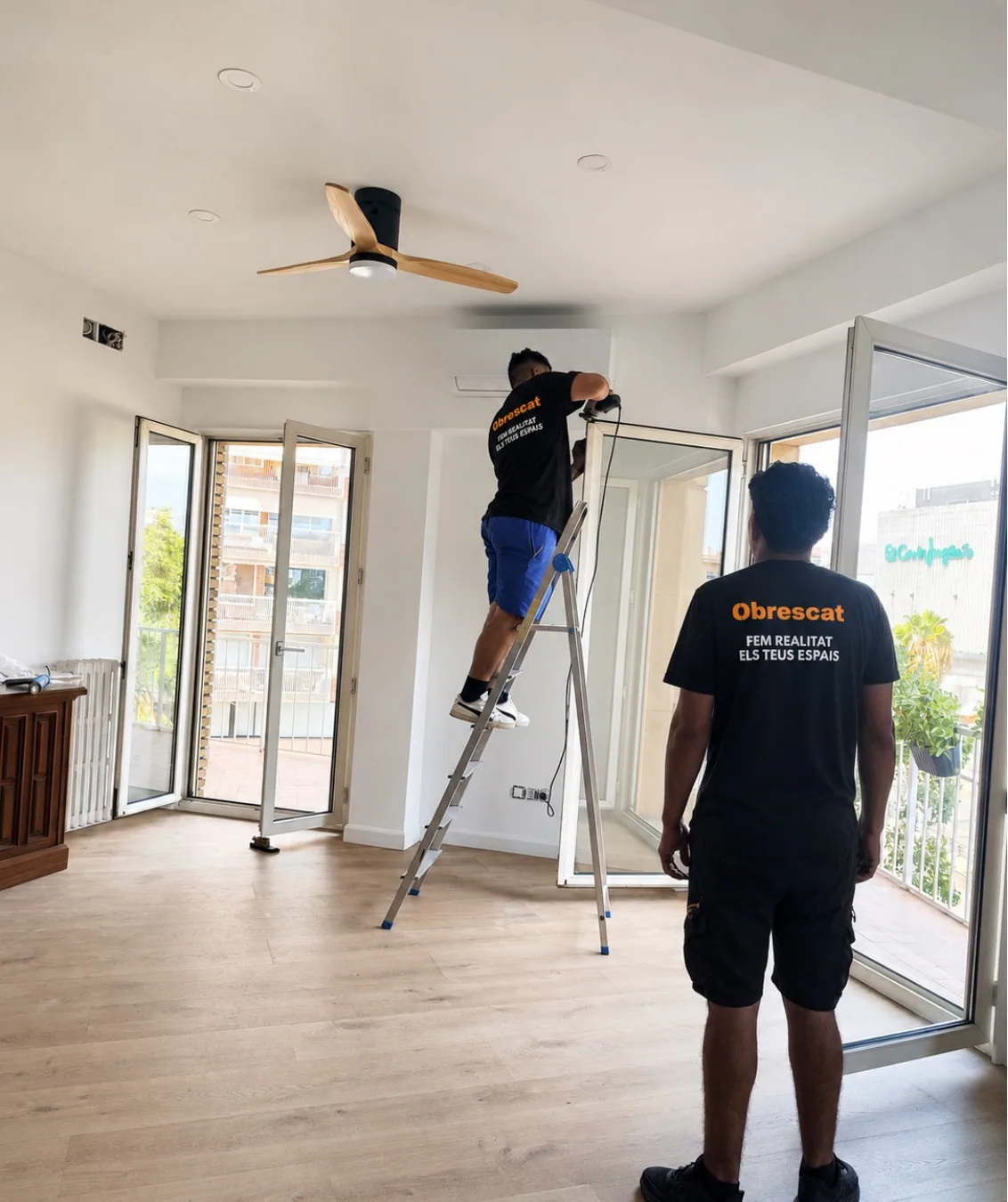Operarios de Obrescat rematando la instalación de un salón reformado con salida a la terraza