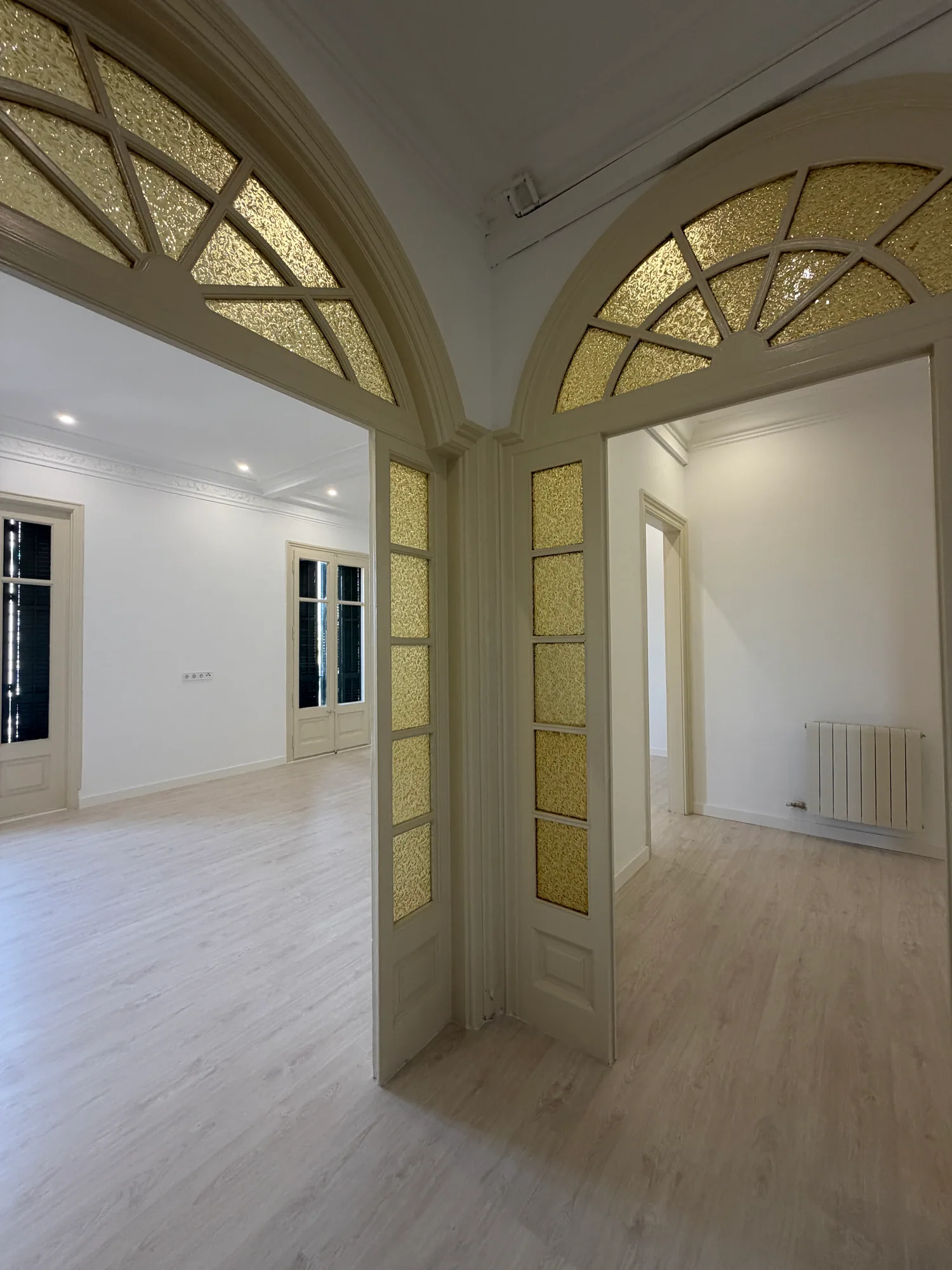 Paso entre el salón y el resto del piso, con los arcos de vidrio emplomado conservados