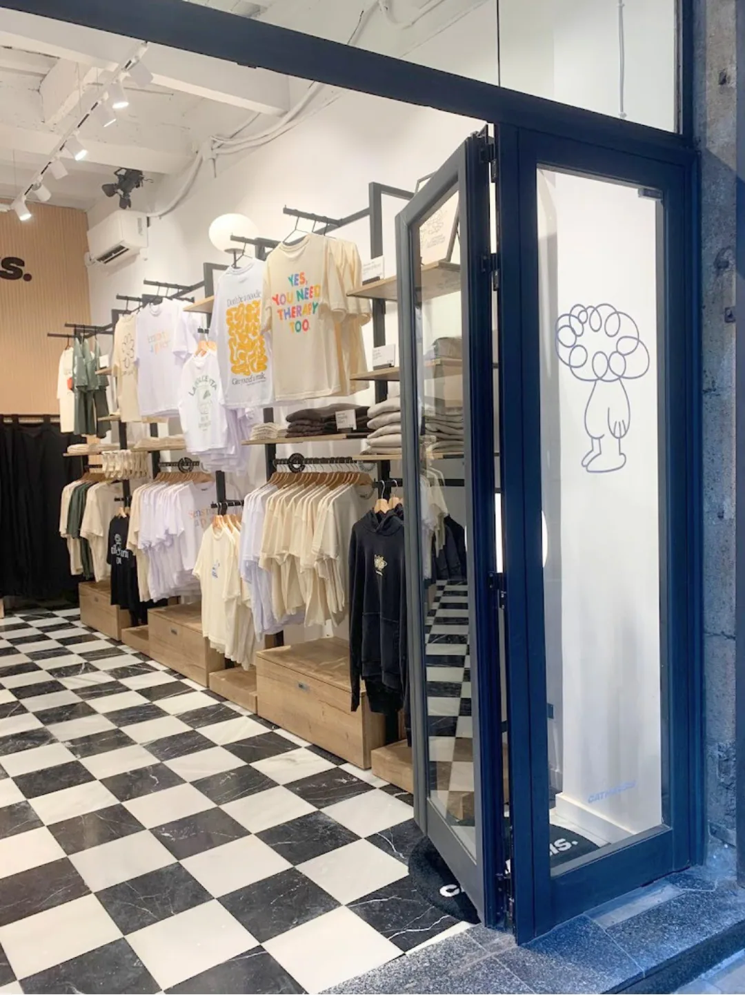 Tienda de ropa terminada, con fachada acristalada abierta a la calle y suelo de baldosa a cuadros