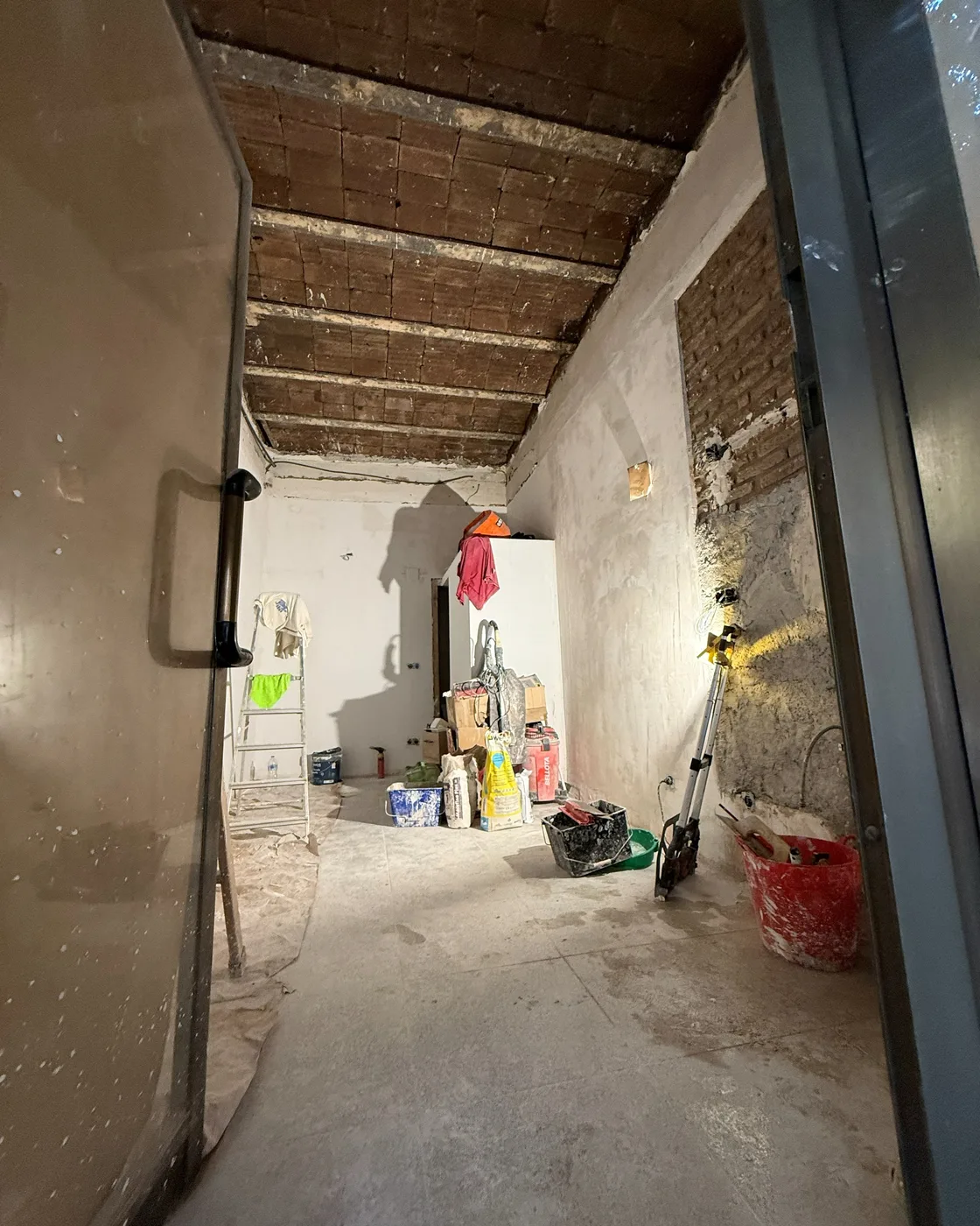 Local en obra amb el sostre de bigues de fusta i revoltó al descobert, reforma d’Obrescat a l’Eixample, Barcelona