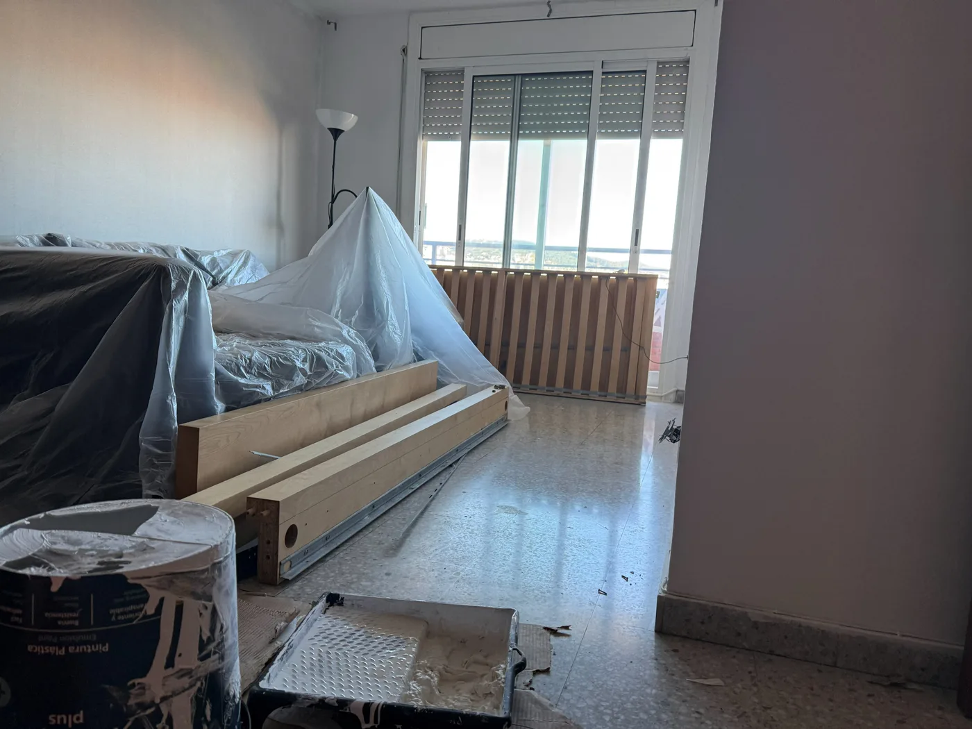 Mobiliari protegit i sòcols preparats abans de canviar el terra d’un habitatge a Sant Martí, Barcelona