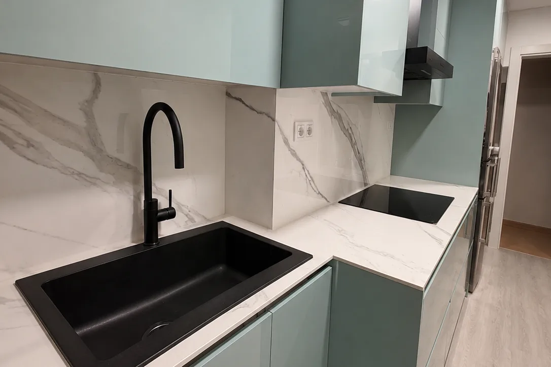 Cuina lineal acabada amb frontal imitació marbre en la reforma d’un local a l’Eixample, Barcelona