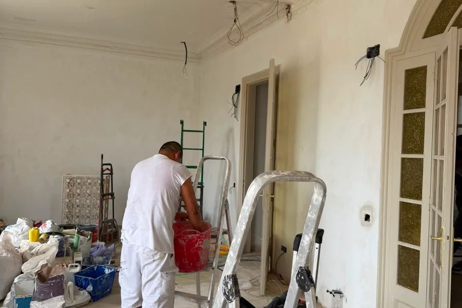 Pintor treballant en una sala amb motllures durant una reforma d’Obrescat a Barcelona